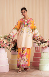 Woman in a floral dress standing among decorated columns with flowers.