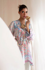 Woman in a patterned dress holding a vintage phone against a plain background