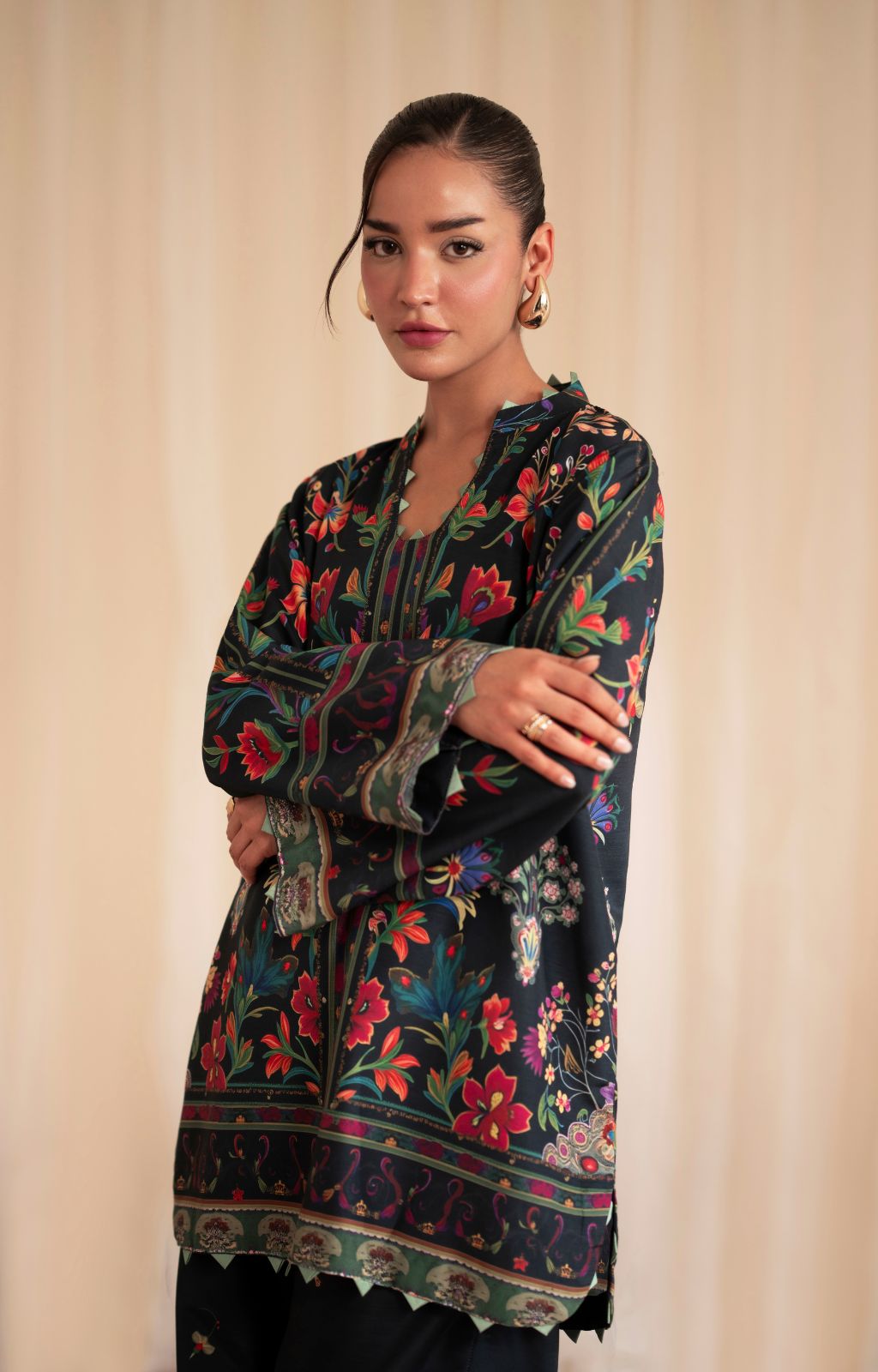 Woman wearing a floral embroidered dress against a beige background