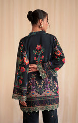 Woman wearing a black embroidered traditional outfit against a beige background