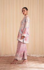 Woman wearing a floral kimono-style outfit with matching pants against a beige curtain background