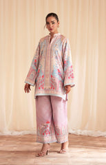 Woman wearing a floral embroidered outfit with a beige curtain background