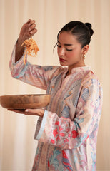 Woman in a floral kimono holding a wooden bowl and noodles against a beige background