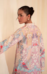 Woman wearing a colorful kimono-style dress with intricate patterns on a beige background