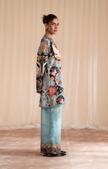 Woman wearing a colorful floral outfit with a plain background
